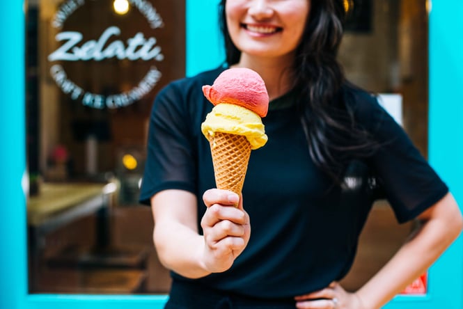 Woman holding ice cream on cone.