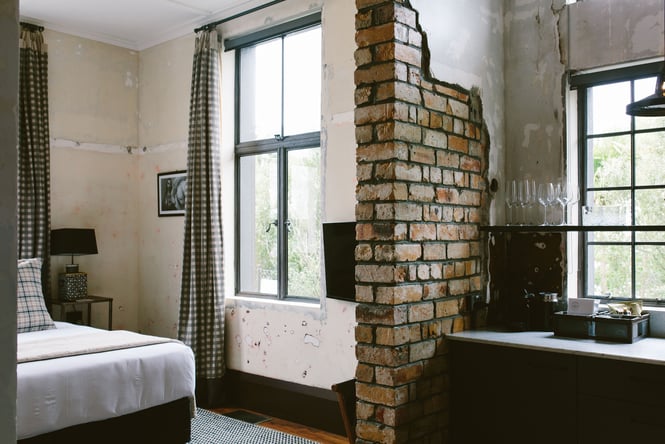 The inside of a room at The Convent Hotel with exposed brick walls.