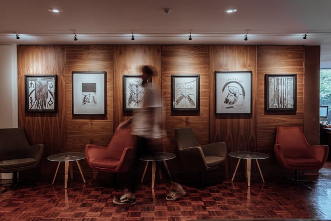 A blurred man walking past a wall of art inside The George.