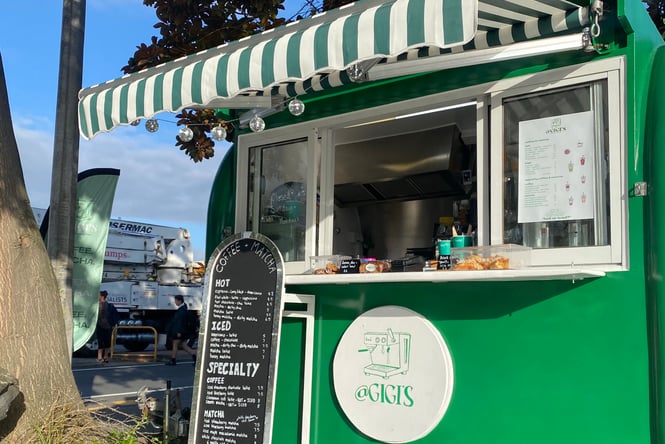 Exterior of Gigi's green matcha cart with green and white awning