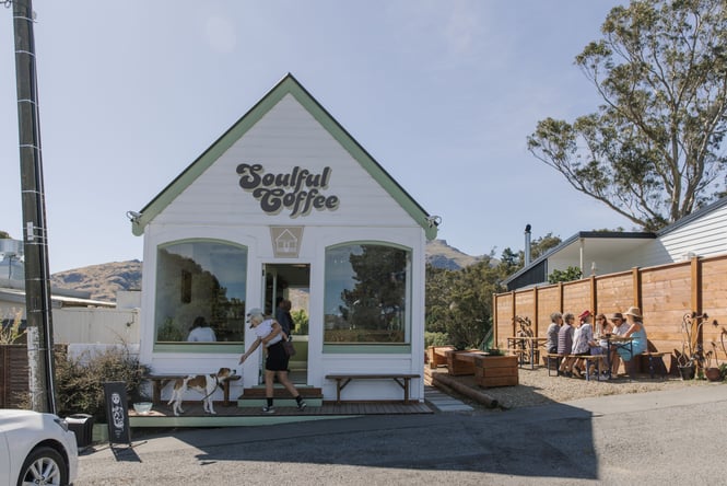 Exterior photo of Soulful Coffee in Diamond Harbour with mother and child standing at doorway patting a dog