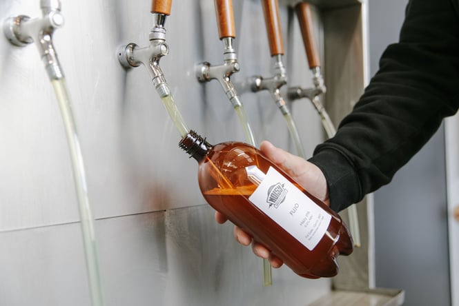 A beer being poured into a bottle.