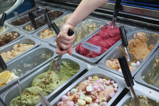 A hand scooping into ice cream.