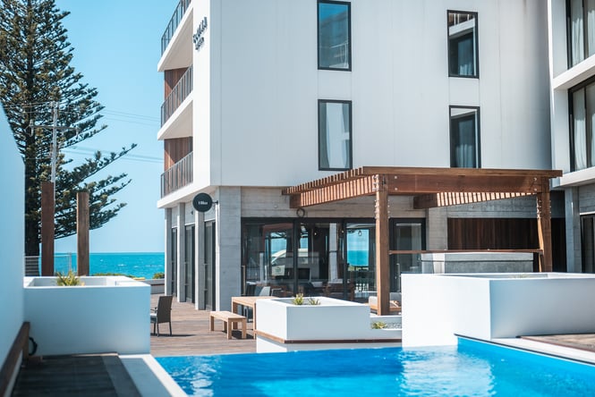 A view of the infinity pool at Sudima Kaikoura hotel with the ocean in the background.