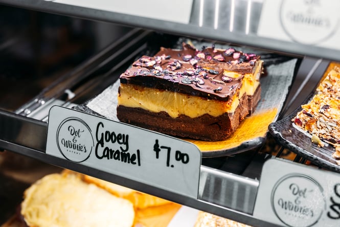 A caramel slice on display in a glass cabinet.