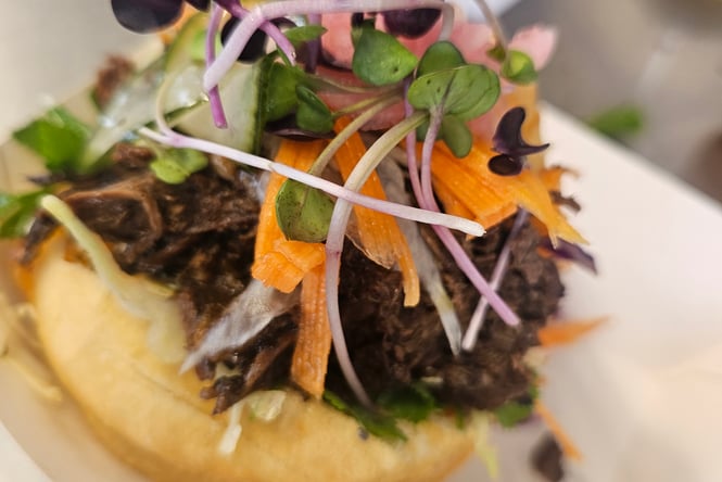 Close up of a tapa with colourful ingredients on top.
