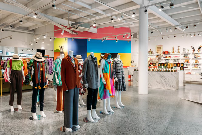 Mannequins wearing colourful clothes in a large retail store.
