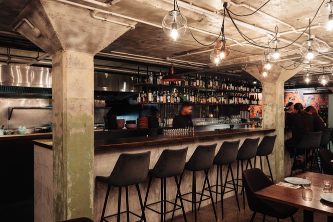 A staff member working behind the empty bar inside Cassia.
