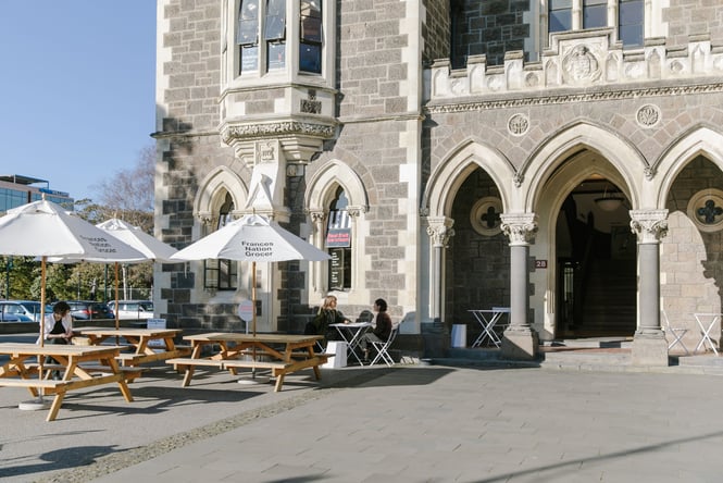 Two people sitting outside Christchurch Arts CEntre.