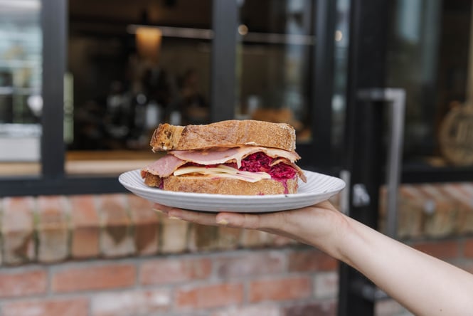 Close up of reuben sandwich on a plate outside Bohemian Bakery