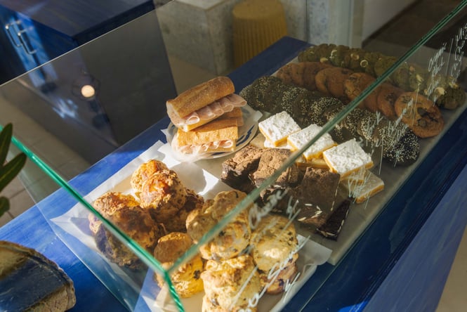 Odds cabinet with simple ham baguettes next to sweet treats