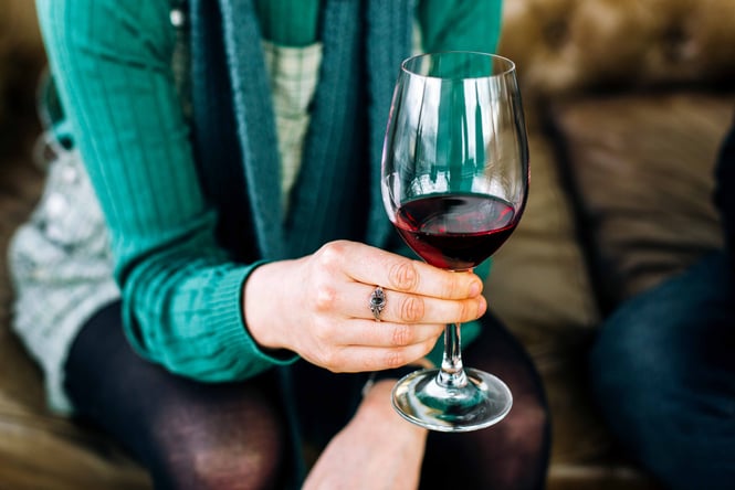 A woman holding a glass of red wine.