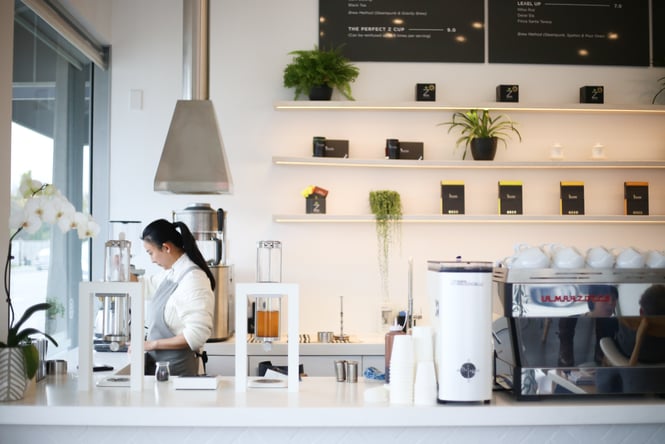 Woman working behind the counter at The Origin, Christchurch.