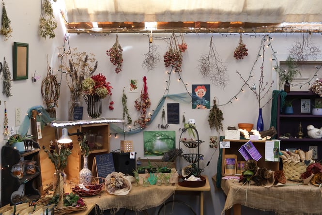 Dried flowers and other homewares on display on a wall and table inside 105 Artisan Emporium New Brighton.