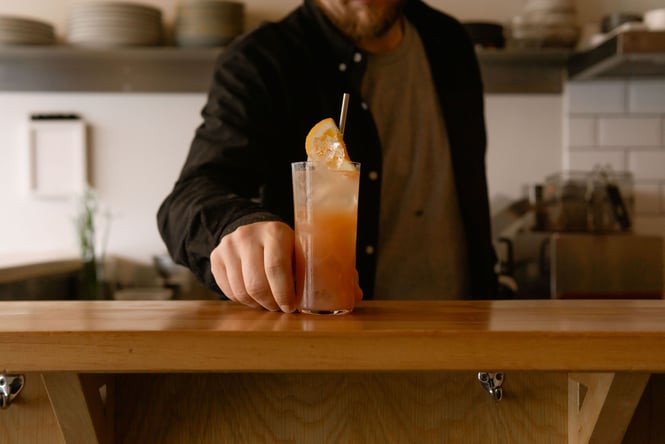 Blood orange coloured cocktail with citrus inside