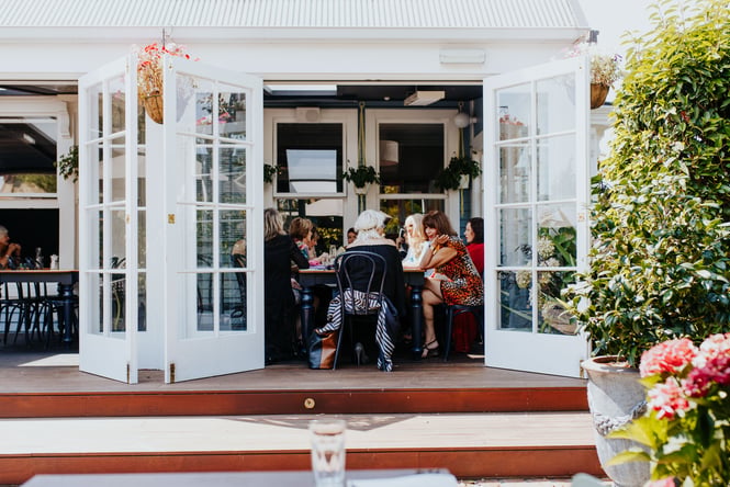 A group of women dining inside Dux Dine on a sunny day.