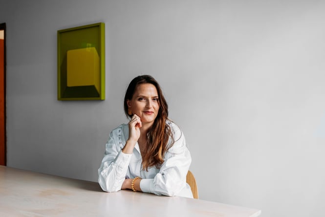 Woman sitting at a table with her hand resting on her face.