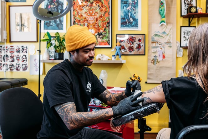 Tattooist working on a customer's arm.