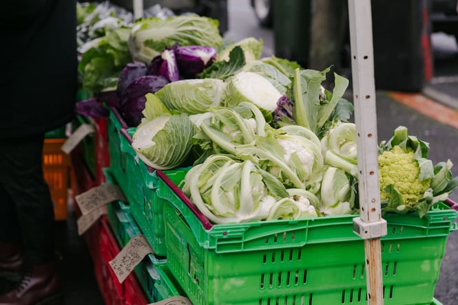 Cauliflowers in a crate at a market stall.