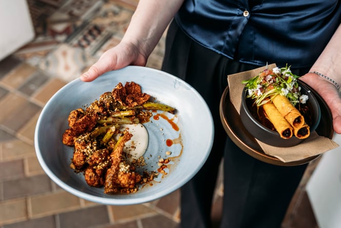Wait staff holding food dishes at Libre.