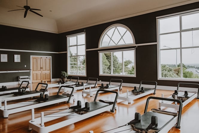 Reformer machines lined up on a wooden floor.