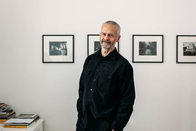 A man wearing black smiling to camera.