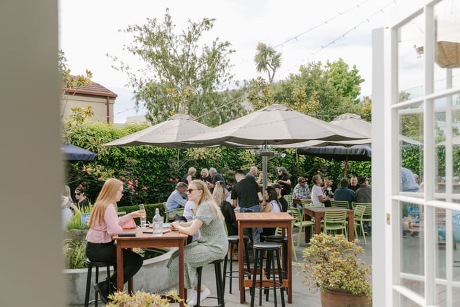 People dining outside on tables at Dux Dine.