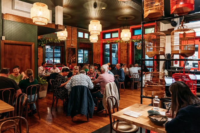 Dining room of a restaurant filled with customers sitting at tables.