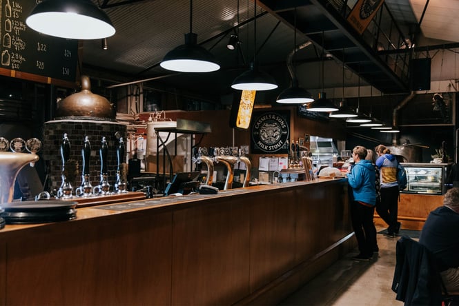 Customers ordering at a long bar counter.