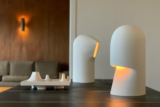 Two lampshade ceramics by Gidon Bing sitting on a wooden table.
