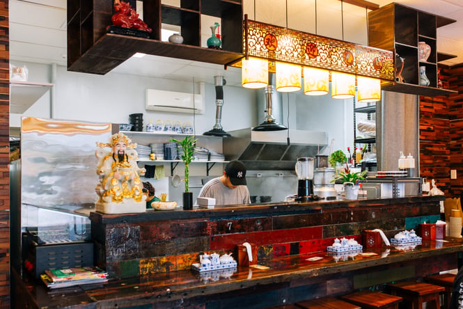 Chef working in the kitchen at Garden Place Noodle Bar.