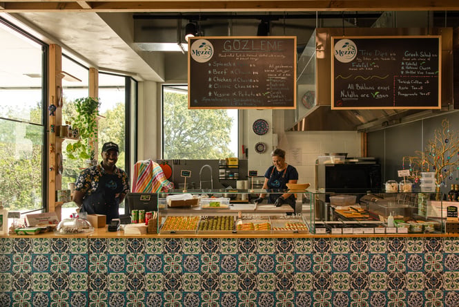 Staff stand behind the front counter and in the kitchen at Mezze & More.