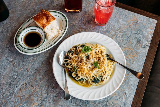 Bowl of spaghetti and a plate of focaccia on the table at Reggies.