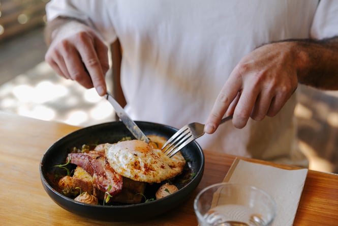 Customer cutting into dish at Sime's Kitchen.