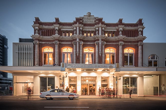 The Isaac Theatre Royal lit up at night.