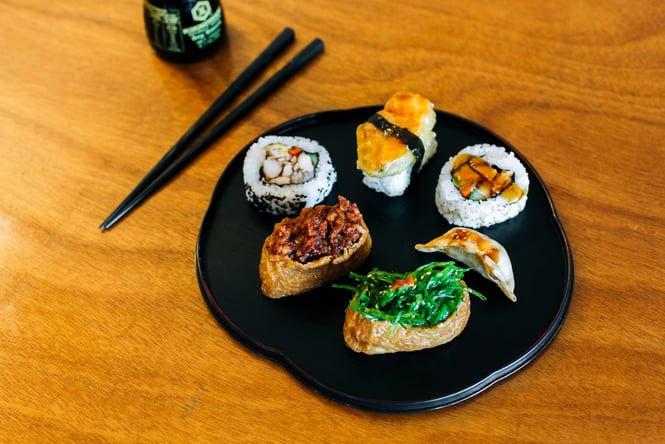 Pieces of sushi displayed neatly on a round black plate.