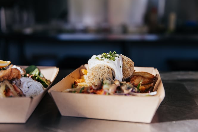 Falafel, salad and chips in cardboard boxes.