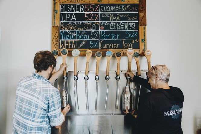 Two people pouring beer.