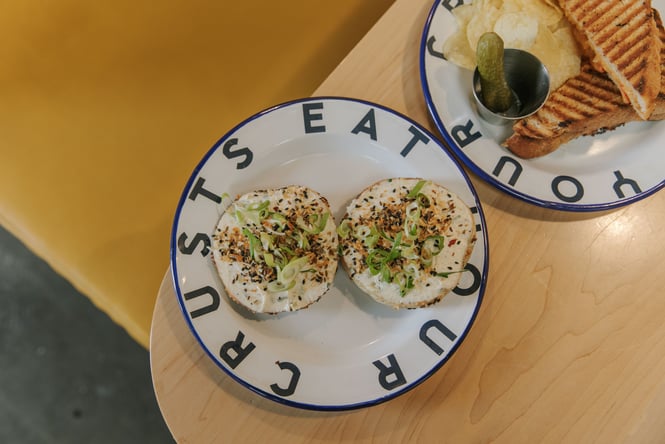 Bagels on plates on a table at Grizzly Baked Goods.