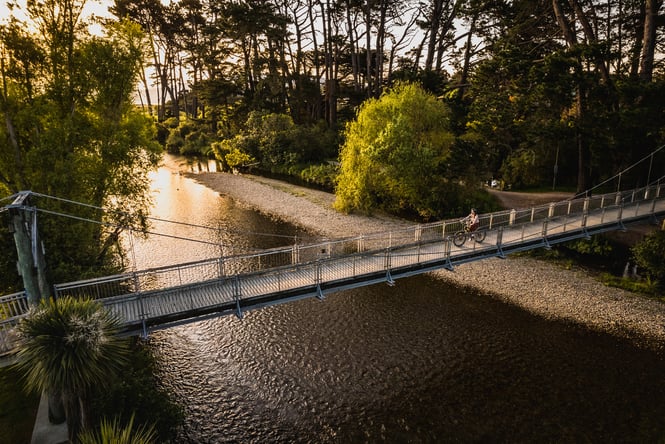 Cyclist going over the bridge on the Waikanae River Trail.