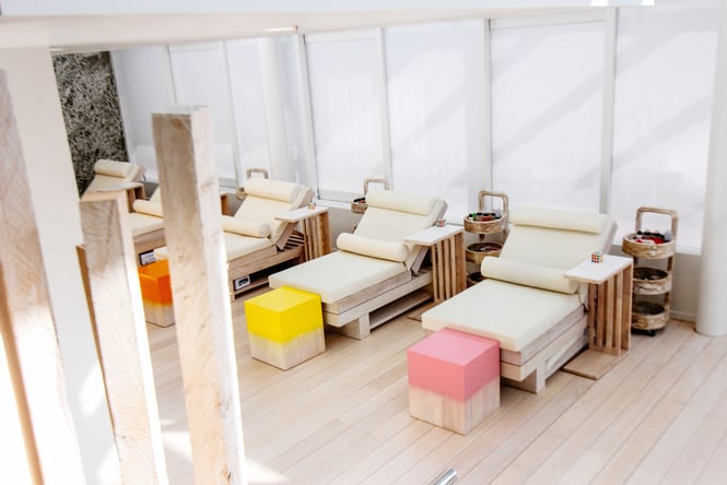 Spa beds lined up in a row inside a brightly lit spa.