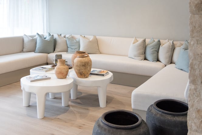 Light and bright waiting room interior at day spa with a large white couch