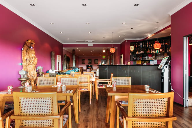 Pink walls in the dining room with tables and chairs.