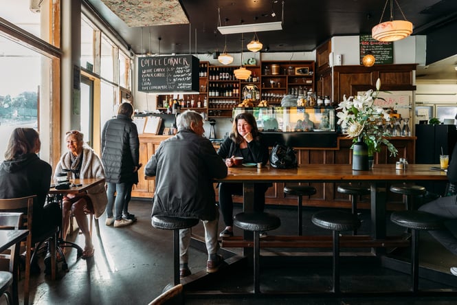 Customers sitting at a table with the front counter in the background.