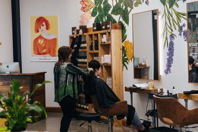 Hairdresser blowing drying someones hair at Earth Organic Hairdressing.