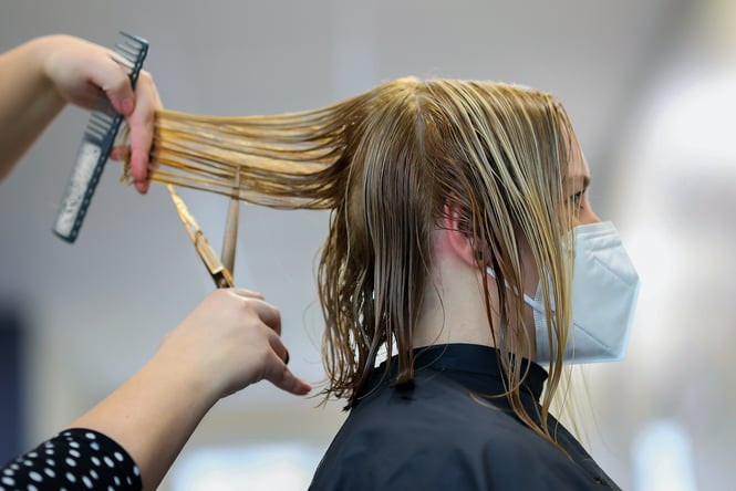 Suheyl Burak Close up of woman having her hair cut.