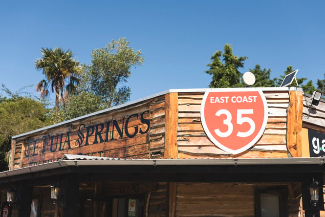 Wooden exterior of Te Puia Springs Store with signage at the top of the building.