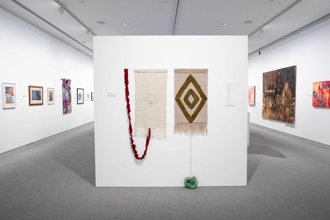 Colourful painted works of art on display on white walls inside Ashburton Art Gallery.