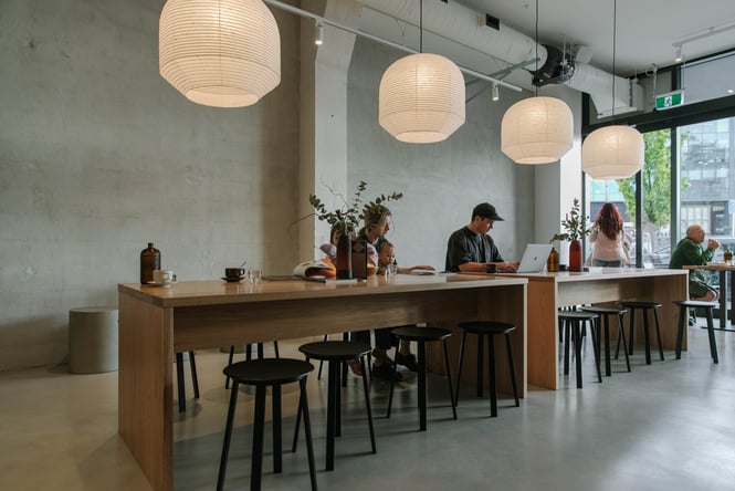 People working at the communal table at Akin.