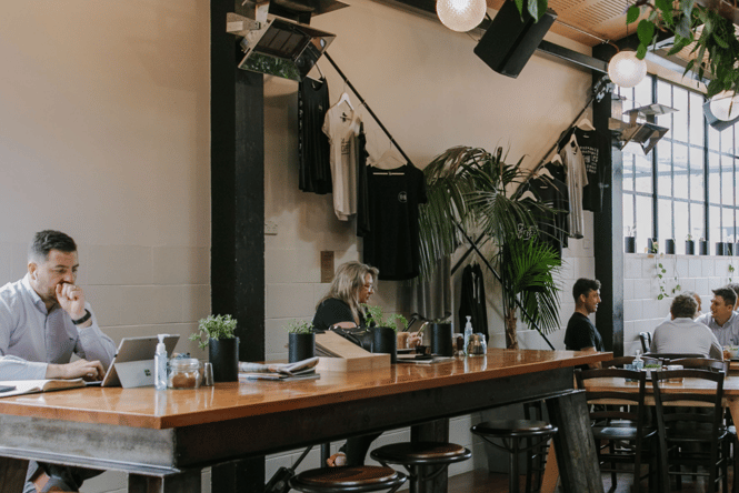 People working at communal table at C4.